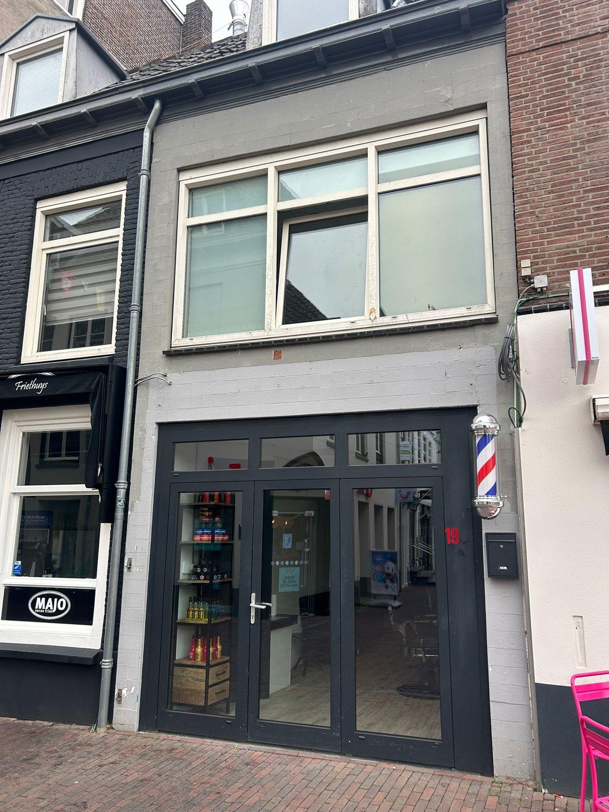 De gevel van Schaar & Ziel aan de Markt 19 in Harderwijk, met de kapperspaal naast de glazen deuren